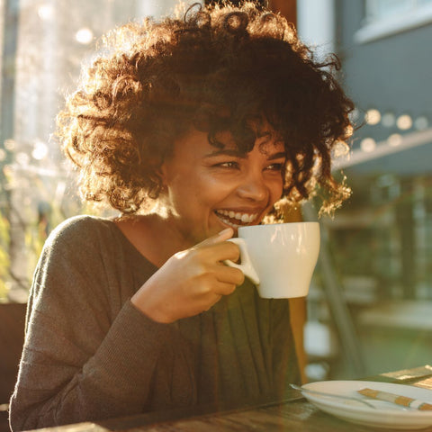 woman drinking coffee with huge smile