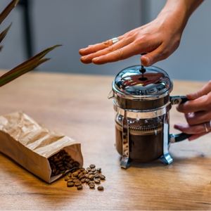 hands pressing coffee in a french press